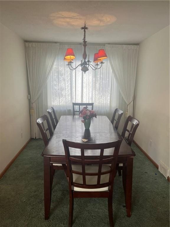 carpeted dining room with a chandelier