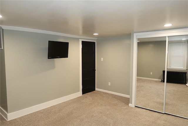 basement with light carpet and ornamental molding