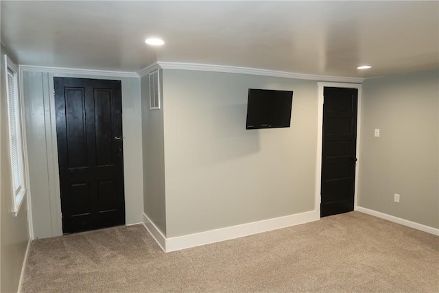 foyer entrance featuring light carpet and ornamental molding