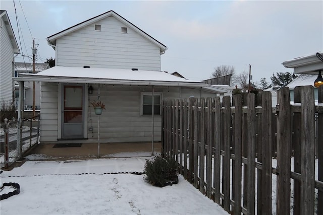 view of snow covered rear of property