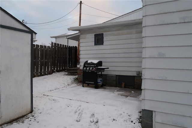 snow covered patio featuring grilling area