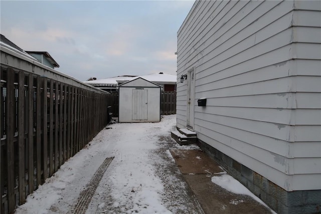 view of snowy exterior featuring a storage unit