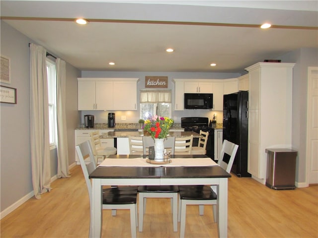 kitchen featuring black appliances, a healthy amount of sunlight, white cabinets, and light hardwood / wood-style flooring