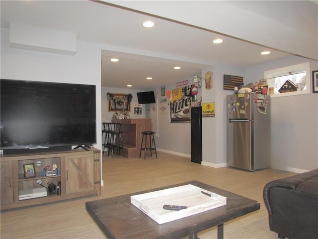 living room featuring bar area and hardwood / wood-style flooring