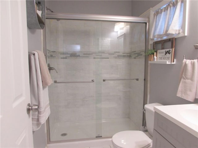 bathroom featuring vanity, toilet, and walk in shower