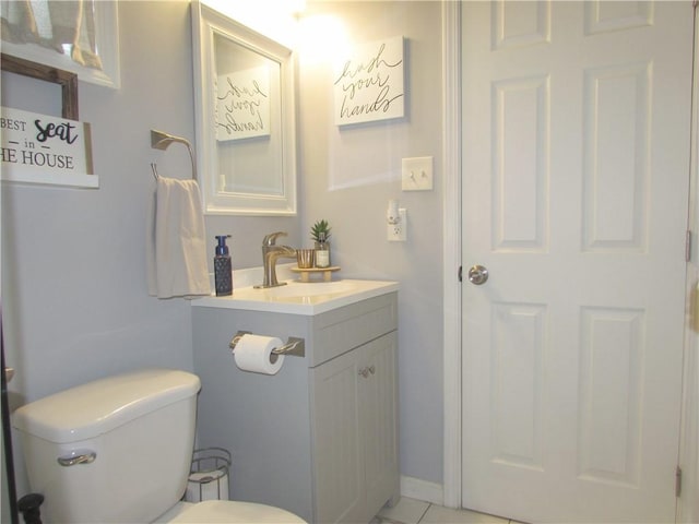 bathroom with tile patterned flooring, vanity, and toilet