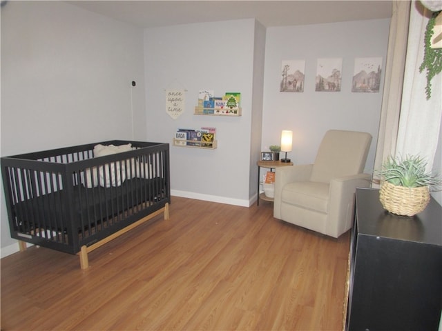 bedroom featuring hardwood / wood-style floors and a crib