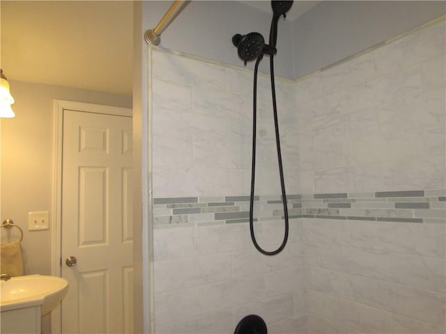 bathroom featuring a tile shower and sink