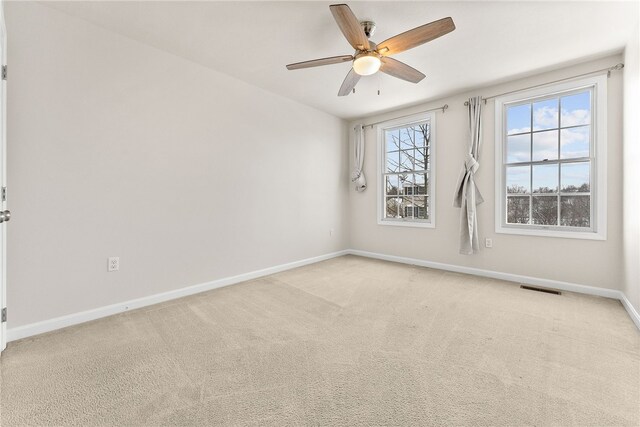 unfurnished room with ceiling fan and light colored carpet