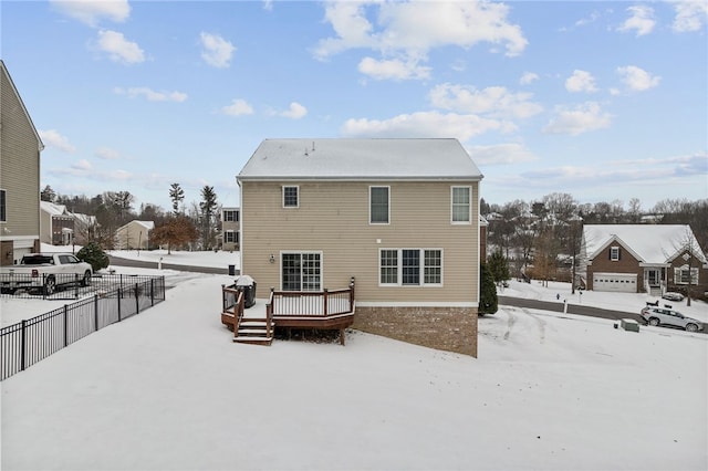 snow covered rear of property featuring a wooden deck