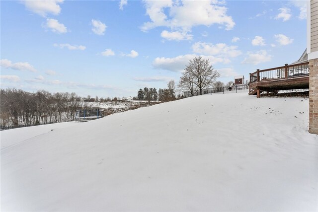 yard layered in snow featuring a trampoline