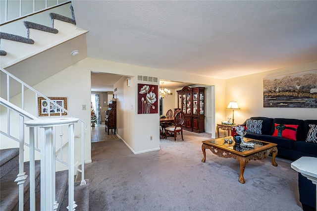 living room with a chandelier, a textured ceiling, carpet floors, and lofted ceiling