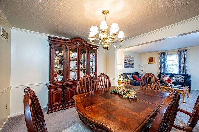 carpeted dining room featuring ornamental molding, a textured ceiling, and a chandelier