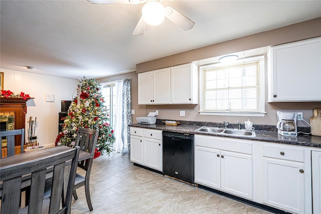 kitchen with ceiling fan, sink, dark stone countertops, dishwasher, and white cabinetry