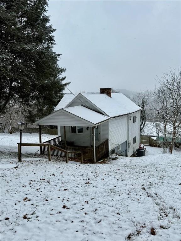 view of snow covered rear of property