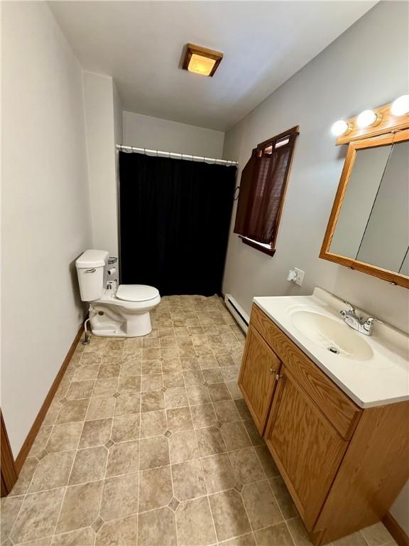 bathroom featuring vanity, toilet, walk in shower, and a baseboard heating unit