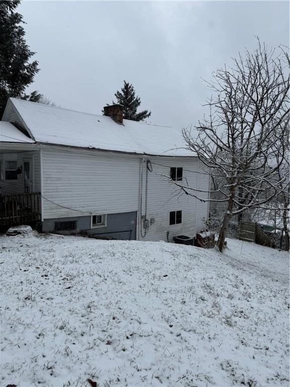 view of snow covered back of property