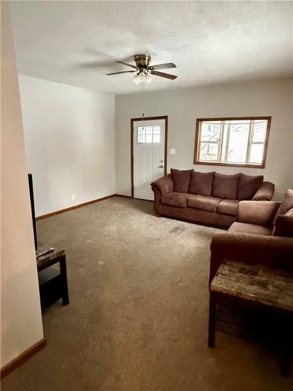 living room featuring a textured ceiling, carpet flooring, a wealth of natural light, and ceiling fan