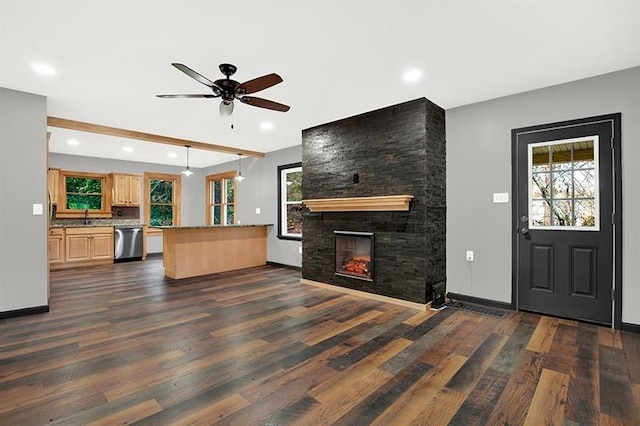 interior space featuring kitchen peninsula, a fireplace, ceiling fan, decorative light fixtures, and dishwasher