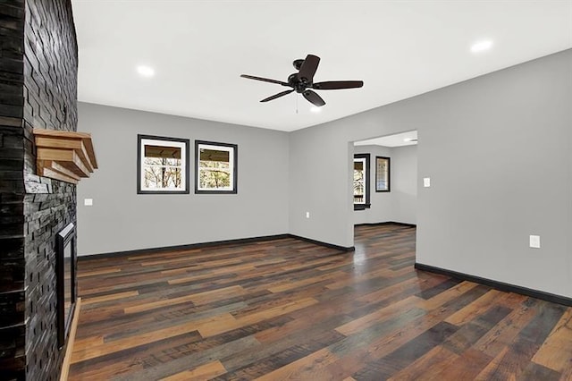 unfurnished living room featuring a fireplace, dark hardwood / wood-style floors, and ceiling fan