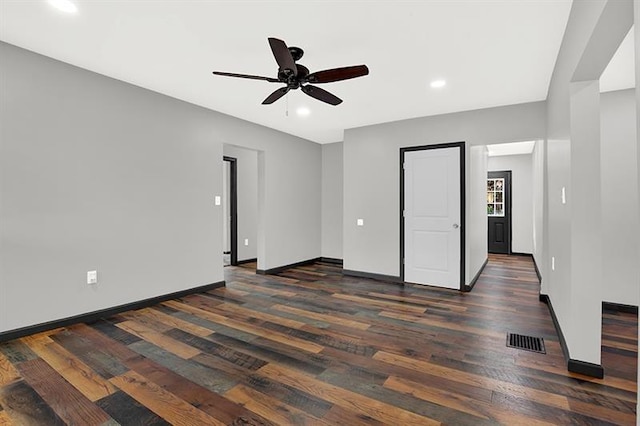 unfurnished bedroom with ceiling fan and dark wood-type flooring