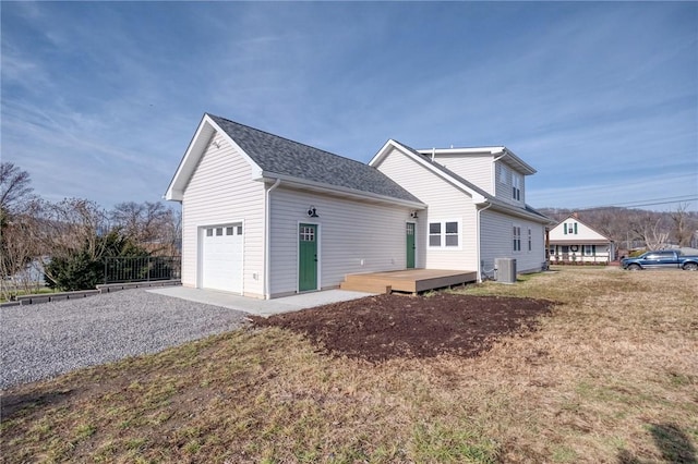 view of home's exterior featuring cooling unit, a garage, and a deck