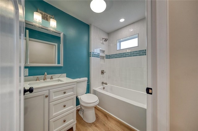 full bathroom with hardwood / wood-style flooring, tiled shower / bath combo, toilet, and vanity