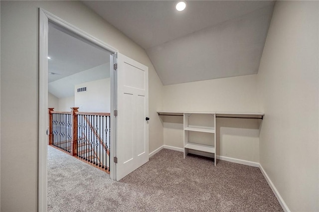 walk in closet featuring carpet floors and vaulted ceiling