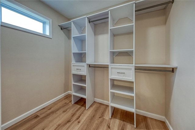 walk in closet with light hardwood / wood-style flooring