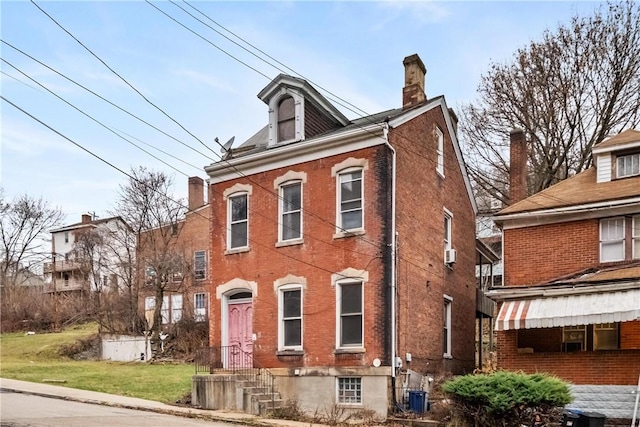 view of front facade with a front lawn and central AC