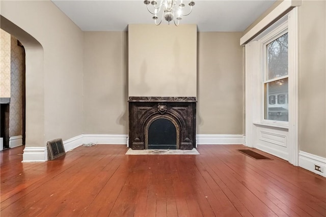 unfurnished living room featuring wood-type flooring and a chandelier