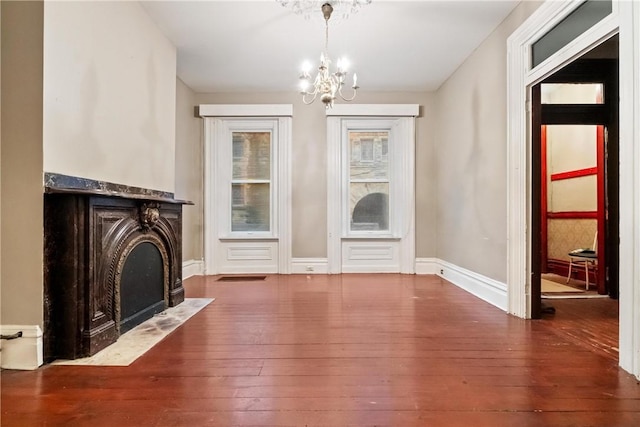 unfurnished living room with dark hardwood / wood-style floors and an inviting chandelier