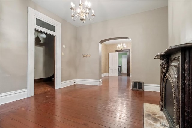 spare room featuring dark hardwood / wood-style floors and a notable chandelier