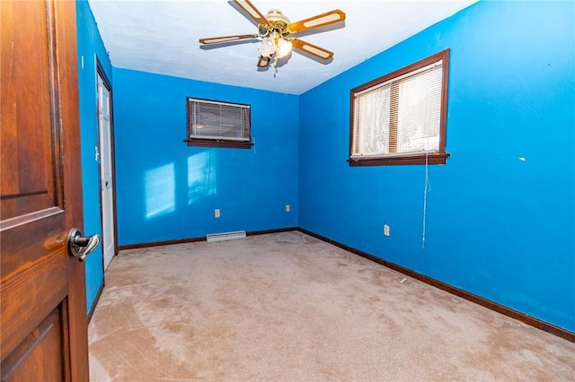 carpeted spare room featuring ceiling fan