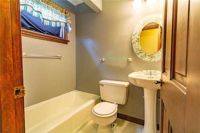 bathroom with tile patterned floors, sink, toilet, and a tub to relax in