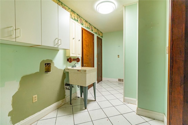 laundry area with cabinets and light tile patterned floors