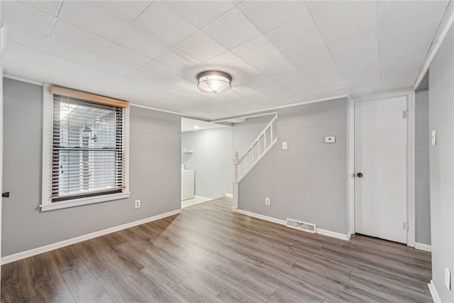 spare room with washer / dryer and hardwood / wood-style flooring