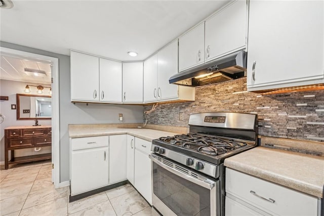 kitchen featuring gas range, sink, tasteful backsplash, track lighting, and white cabinets