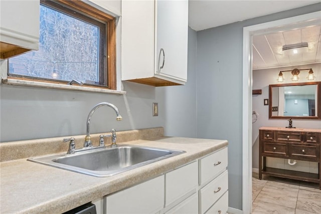 kitchen featuring white cabinetry and sink