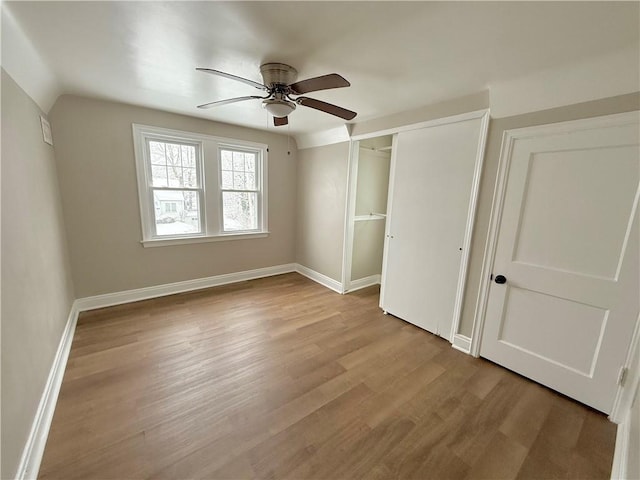 unfurnished bedroom featuring light wood-type flooring, a closet, vaulted ceiling, and ceiling fan