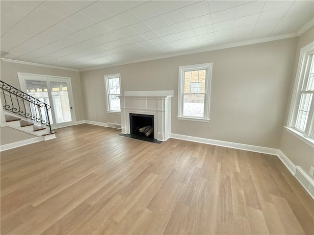 unfurnished living room featuring light hardwood / wood-style flooring and ornamental molding