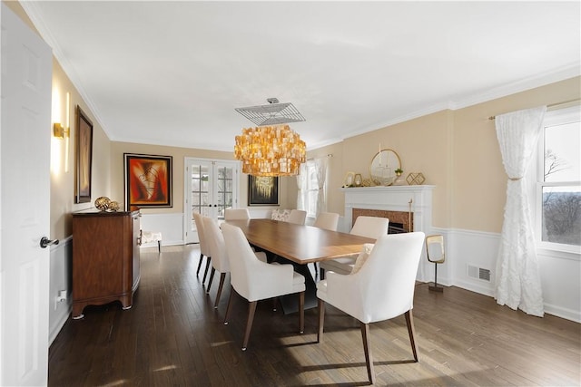 dining area featuring a chandelier, crown molding, and dark wood-type flooring