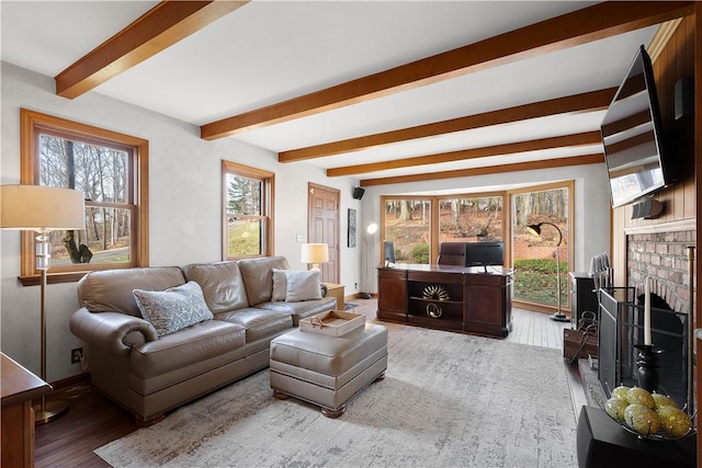 living room featuring beam ceiling, wood-type flooring, and a fireplace