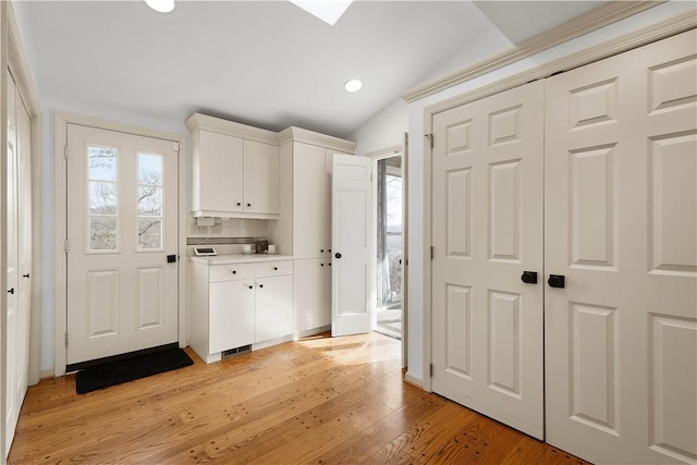 interior space featuring lofted ceiling and light wood-type flooring