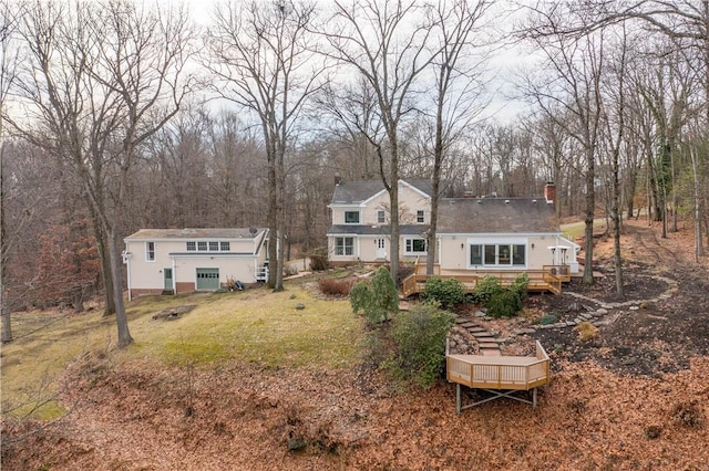 rear view of property with a deck and a yard