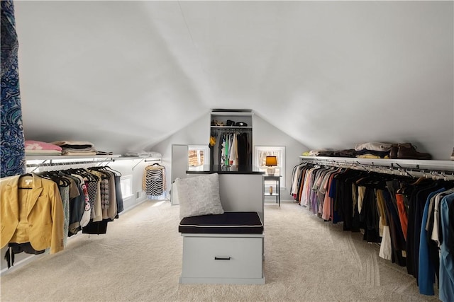 walk in closet featuring light colored carpet and lofted ceiling