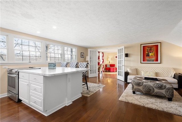 kitchen with white cabinetry, electric range, french doors, dark hardwood / wood-style flooring, and a textured ceiling