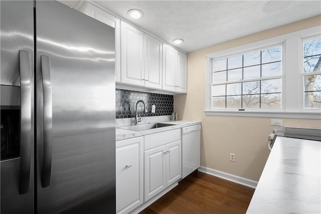 kitchen with backsplash, stainless steel appliances, dark wood-type flooring, sink, and white cabinets