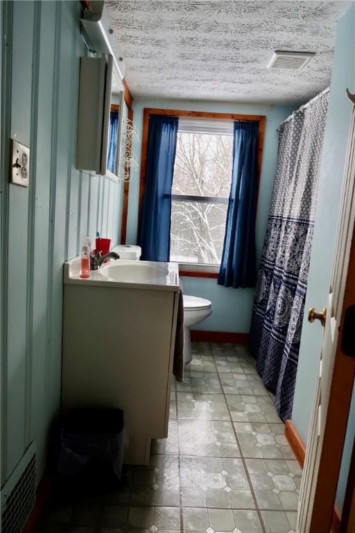 bathroom featuring vanity, toilet, and a textured ceiling