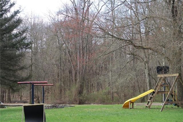 view of yard with a wooded view and playground community